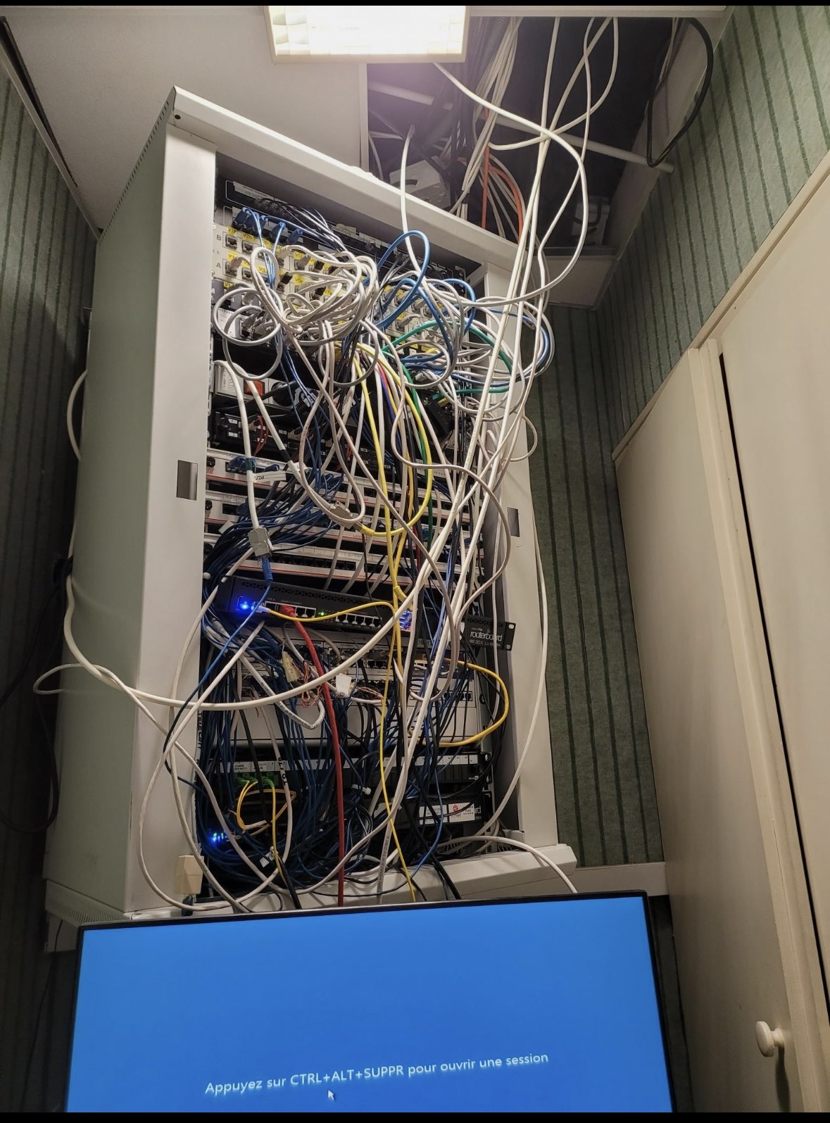 Baie réseau avant réorganisation avec câblage dense à la mairie de Gray